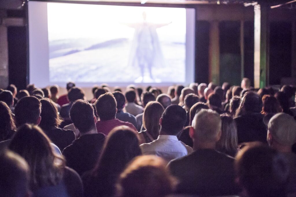 A view from the back of a packed cinema during a film.